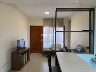 Ambiente interno de uma sala com porta de madeira e cortinas claras.