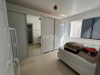 Quarto moderno com armários embutidos e janela de grande porte.