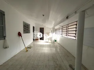 Foto de um corredor interno com paredes brancas e piso de cerâmica.