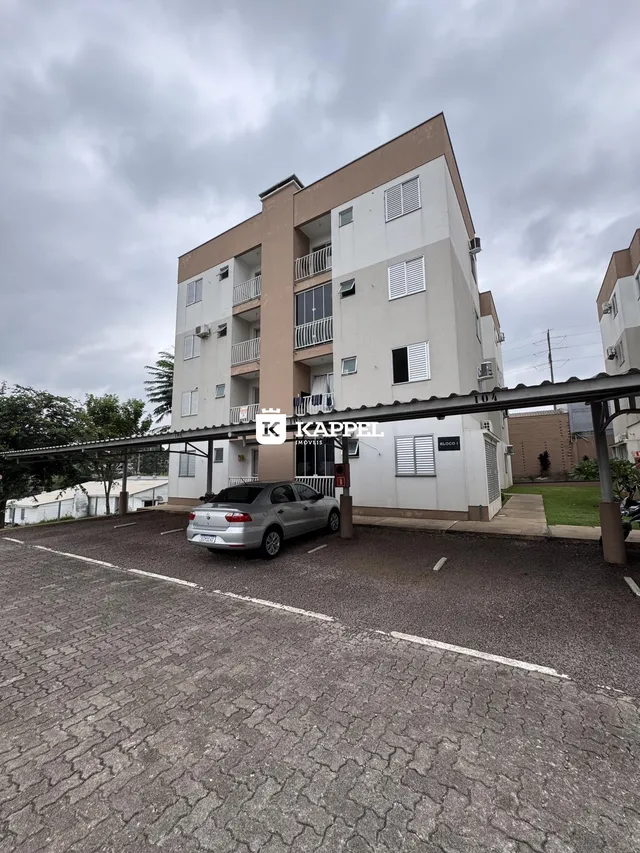 Fachada de um prédio residencial em Lajeado, Brasil, com área de estacionamento em primeiro plano.