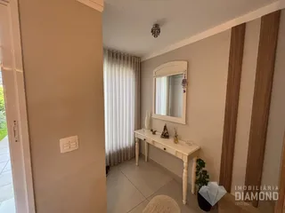 Interior de um ambiente com parede clara e cortinas claras.