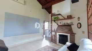 Sala de estar com parede azul e lareira de tijolos.