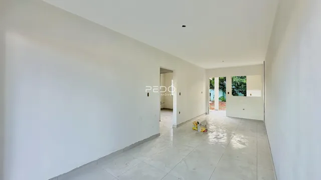 Hall de entrada com paredes brancas e piso de cerâmica.