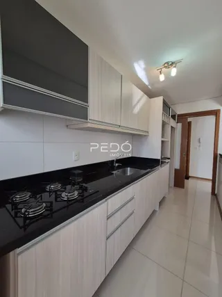 Cozinha moderna com armários brancos e bancadas escuras.