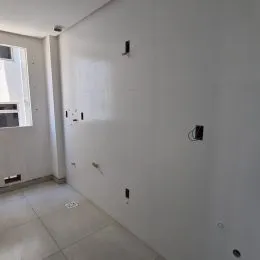 Foto de um corredor interno com paredes brancas.