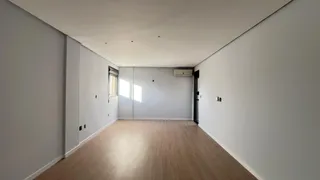 Sala de estar com piso de madeira e paredes brancas.