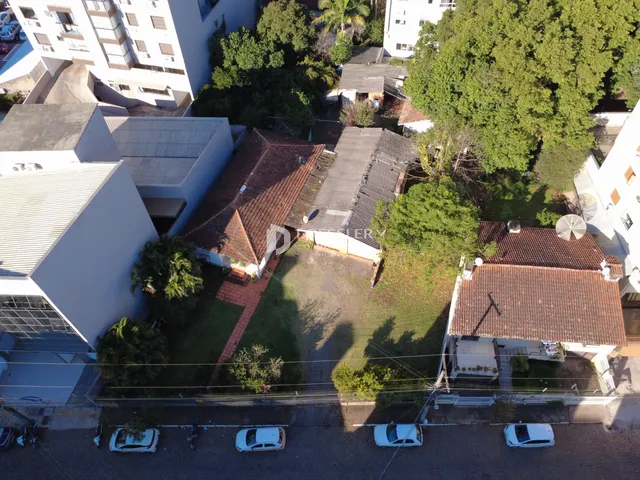 Vista aérea de um complexo residencial com telhados de telhas vermelhas e vegetação.