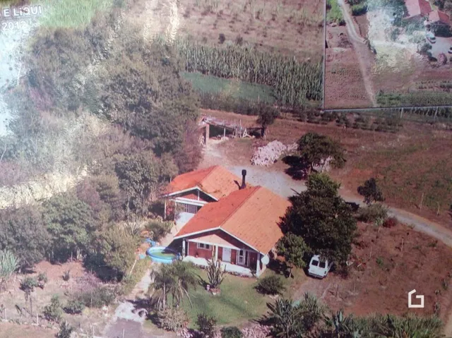 Vista aérea de uma propriedade rural com campos ao redor.