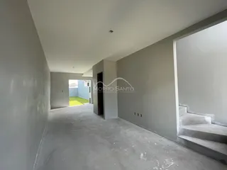 Hall de entrada com paredes cinzas e piso de concreto em uma residência.