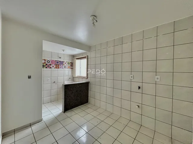 Hall de entrada com piso e paredes revestidos de cerâmica branca.