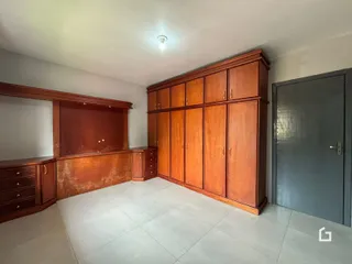 Um cômodo interno com armários de madeira e piso de cerâmica.