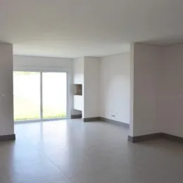 Ambiente interno amplo com paredes brancas e piso claro.