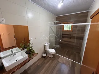 Foto de um banheiro com pias e box de vidro em um imóvel.