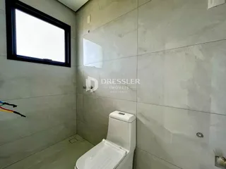 Foto de um banheiro com paredes revestidas em cerâmica cinza.