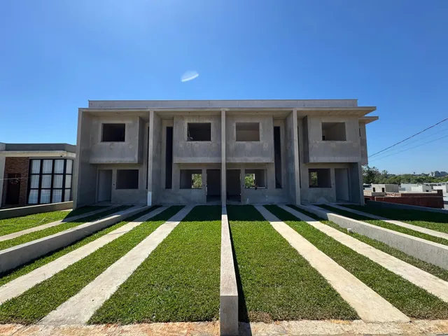Fachada frontal de uma casa moderna com paisagismo e calçadas.