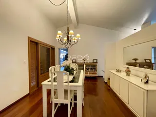 Interior de uma sala de jantar com piso de madeira e portas de madeira.