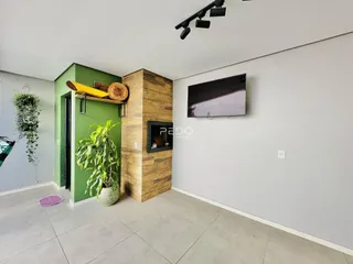Sala de estar com parede verde e detalhes em madeira na residência.
