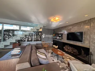 Sala de estar moderna com lareira e grande janela.