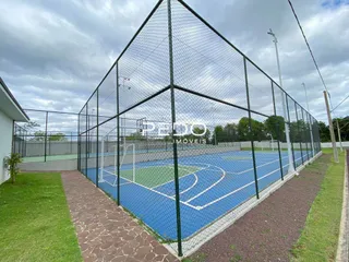 Vista de uma quadra esportiva externa cercada por uma cerca.