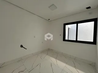 Ambiente interno de uma sala com piso de mármore claro e paredes brancas.