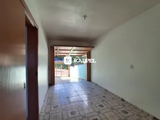 Corredor interno com piso de cerâmica e paredes brancas.