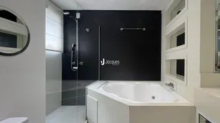 Foto de um banheiro moderno com banheira e box de vidro.
