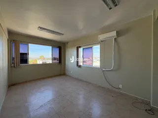 Sala com piso de cerâmica e janelas amplas.