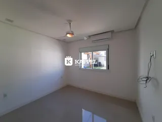 Foto de um ambiente interno claro com piso de porcelanato e ar-condicionado instalado.