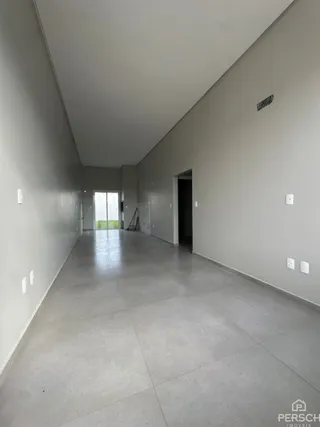 Corredor longo e vazio com piso de cerâmica e paredes claras.