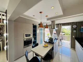 Interior de uma cozinha moderna com armários cinzas e piso claro.