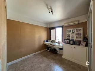 Foto de uma sala com paredes bege e piso de cerâmica.