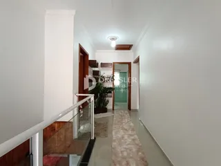 Hall de entrada com piso claro e paredes brancas.