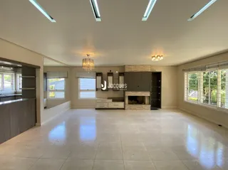 Sala ampla com piso claro e lareira no interior da residência.