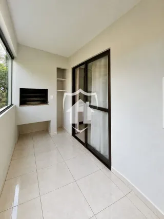 Hall de entrada com piso de cerâmica clara e portas de vidro.