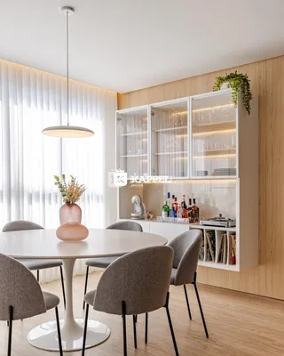 Uma mesa redonda com cadeiras está em um ambiente interno bem iluminado.