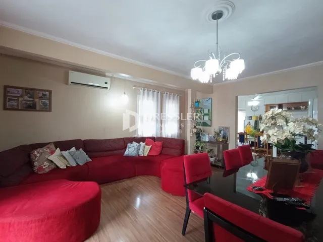 Sala de estar com sofá vermelho e cadeiras vermelhas em um imóvel no Brasil.