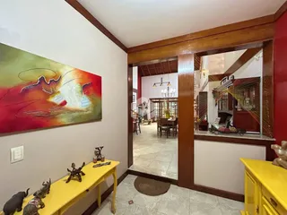 Hall de entrada com parede decorada e móvel amarelo.