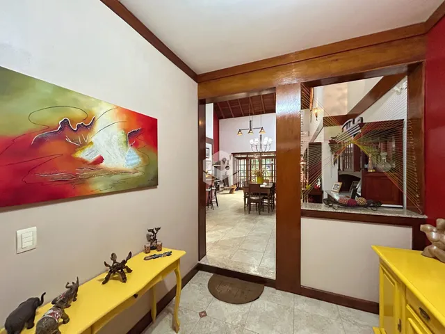 Hall de entrada com parede decorada e móvel amarelo.