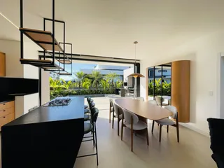 Ambiente de sala de estar e jantar com vista para o jardim externo.