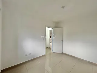 Vista de um corredor interno com piso de cerâmica clara.