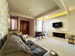 Sala de estar com sofá e lareira.