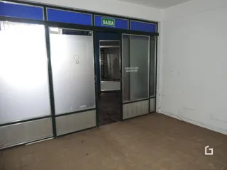 Vista da entrada com portas de vidro e piso de concreto.