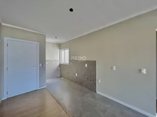 Hall de entrada com piso de madeira e parede clara.