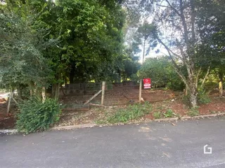 Vista externa da propriedade com cerca e vegetação densa.