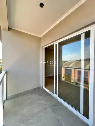 Vista interna de um ambiente com porta de vidro que se abre para o exterior.