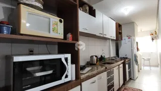 Vista interna de uma cozinha com armários e eletrodomésticos.