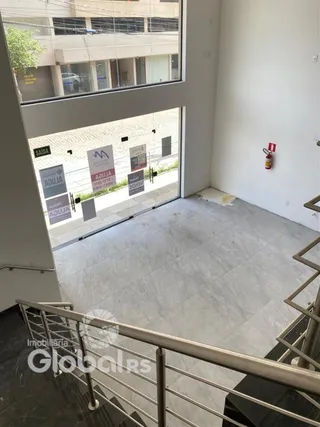 Vista interna de um ambiente com piso de cerâmica e porta de vidro.