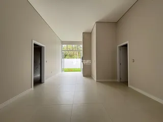 Hall de entrada com piso claro e paredes brancas.