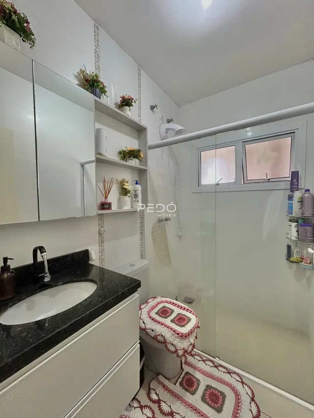 Foto de um banheiro com box de vidro e revestimento branco.