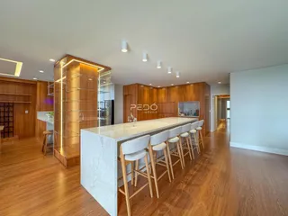 Imagem de uma cozinha moderna com ilha e armários de madeira.